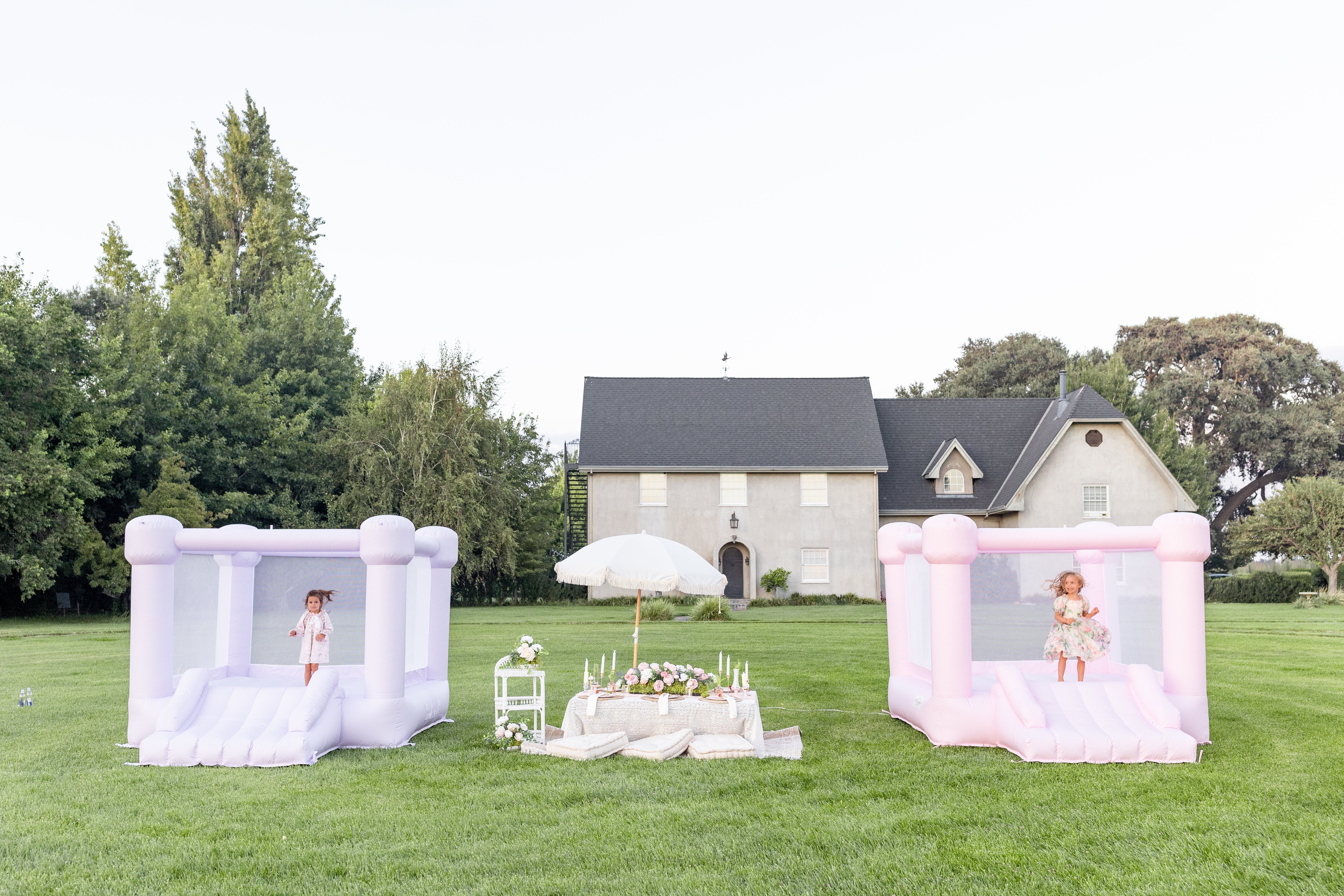 Pastel inflatable bounce house, pink and purple.